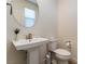 Clean and modern bathroom with pedestal sink, toilet and large mirror at 2966 Gallarate Dr, Henderson, NV 89044