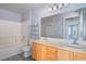 Bathroom with double vanity, tub, and light wood cabinets at 5710 E Tropicana Ave # 2017, Las Vegas, NV 89122