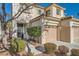 Two-story house with beige exterior, two-car garage, and landscaping at 1624 Ravanusa Dr, Henderson, NV 89052