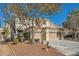 Two-story house with beige exterior, three-car garage, and landscaping at 1624 Ravanusa Dr, Henderson, NV 89052