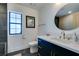 Stylish bathroom featuring a dark vanity, round mirror, and a white toilet at 1860 Ski Slope Cir, Las Vegas, NV 89117