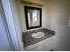 Well-lit bathroom vanity area with a new mirror and granite countertops at 390 China St, Pahrump, NV 89048