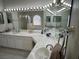 Well-lit bathroom with dual sinks, white cabinets, drop in tub, and large vanity mirrors at 390 China St, Pahrump, NV 89048