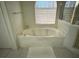 Bright bathroom featuring a drop in bathtub and a white tiled floor at 390 China St, Pahrump, NV 89048