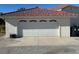 Attached white garage door with small arched windows, matching the stucco exterior at 390 China St, Pahrump, NV 89048