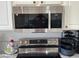 Kitchen features stainless steel microwave, a ceramic cooktop and granite counters at 390 China St, Pahrump, NV 89048