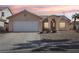 Front view of a single story house with a two-car garage at sunset at 4020 Angel Face St, North Las Vegas, NV 89032