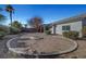 Large backyard with a circular hardscape and decorative shrubbery under a bright blue sky at 5919 Pavilion Lakes Ave, Las Vegas, NV 89122