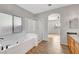 Bathroom with large soaking tub, glass shower, and wood-look flooring at 5919 Pavilion Lakes Ave, Las Vegas, NV 89122
