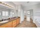 Bright bathroom with double vanity, large mirror, and wood-look flooring at 5919 Pavilion Lakes Ave, Las Vegas, NV 89122