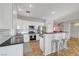 Kitchen with island, seating, white cabinets, stainless steel appliances, and wood flooring at 5919 Pavilion Lakes Ave, Las Vegas, NV 89122