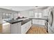 Open kitchen featuring an island with seating, white cabinets, subway tile backsplash, and wood flooring at 5919 Pavilion Lakes Ave, Las Vegas, NV 89122