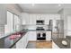 Bright kitchen with white cabinets, stainless steel appliances, subway tile backsplash and dark countertops at 5919 Pavilion Lakes Ave, Las Vegas, NV 89122