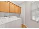 Laundry room featuring a washer, a dryer, and a window for natural light at 5919 Pavilion Lakes Ave, Las Vegas, NV 89122