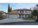 Two-story house with a tan exterior, tile roof, and a two-car garage at 9021 Feather River Ct, Las Vegas, NV 89117