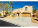 Two-story house with tan exterior, stone accents, and a three-car garage at 9904 Garamound Ave, Las Vegas, NV 89117