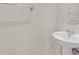 Small bathroom with pedestal sink and a round mirror at 10375 Pescado Ln, Las Vegas, NV 89135