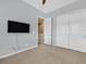 Well-lit bedroom featuring a TV mount, carpet flooring, and double door closet at 10375 Pescado Ln, Las Vegas, NV 89135