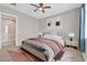 Virtually staged bedroom with a gray bed and ceiling fan at 10375 Pescado Ln, Las Vegas, NV 89135