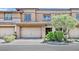 Tan two-story townhome with attached garage and landscaping at 10375 Pescado Ln, Las Vegas, NV 89135