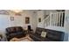 Living room with leather couches and a staircase at 12064 Avery Meadows Ave, Las Vegas, NV 89138