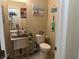 Cozy bathroom with pedestal sink, beach decor, and neutral wall and floor tiles at 181 Elexese Ct, Las Vegas, NV 89183
