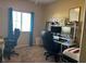 Bedroom with neutral walls, blue curtains, and a workstation including a chair and electronic monitor at 181 Elexese Ct, Las Vegas, NV 89183