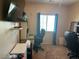 Bedroom with neutral walls, blue curtains, and a workstation including a chair and electronic monitor at 181 Elexese Ct, Las Vegas, NV 89183