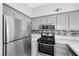 Modern kitchen features stainless steel appliances and gray cabinets at 2251 Wigwam Pkwy # 218, Henderson, NV 89074