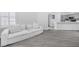 Spacious living room with large off-white couch and gray wood-look floor at 2251 Wigwam Pkwy # 218, Henderson, NV 89074