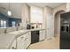 White kitchen cabinets, granite counters, and black appliances at 2520 Links Dr, Laughlin, NV 89029