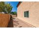 View of backyard featuring a wall with trees and bushes and desert landscaping at 3396 Villa Fiori Ave, Las Vegas, NV 89141