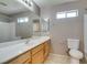 Bright bathroom featuring a single vanity, large mirror, neutral paint, and natural light at 3396 Villa Fiori Ave, Las Vegas, NV 89141