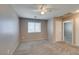 Carpeted bedroom featuring a ceiling fan, a window, and a door to another room at 3396 Villa Fiori Ave, Las Vegas, NV 89141