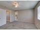 Cozy bedroom featuring plush carpeting, ceiling fan, natural light, and a convenient interior door at 3396 Villa Fiori Ave, Las Vegas, NV 89141