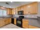 Bright kitchen featuring wood cabinets, modern black appliances and plenty of counter space at 3396 Villa Fiori Ave, Las Vegas, NV 89141