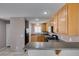 Well-equipped kitchen with wood cabinetry, gas range, and breakfast bar counter at 3396 Villa Fiori Ave, Las Vegas, NV 89141