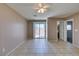 Spacious living room with neutral paint, tile flooring, ceiling fan and sliding glass door at 3396 Villa Fiori Ave, Las Vegas, NV 89141