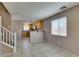 Living room with view into the kitchen, features tile floor and staircase at 3396 Villa Fiori Ave, Las Vegas, NV 89141