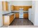 Kitchen with wood cabinets, white appliances, and laminate flooring at 43 Pangloss St, Henderson, NV 89002