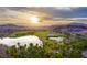 Aerial view of a golf course community at sunset with lake views at 52 Reverie Heights Ave, Henderson, NV 89011