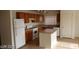 Kitchen with island, wood cabinets and white appliances at 5987 Stone Hollow Ave, Las Vegas, NV 89156
