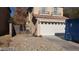 Two-story house exterior with a gravel driveway and a blue dumpster at 6684 Coronado Crest Ave, Las Vegas, NV 89139