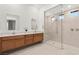 Open bathroom featuring dual vanities, framed mirrors, quartz countertop, and a glass enclosed walk-in shower at 177 Cactus Sunrise St, Las Vegas, NV 89138