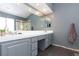 Bathroom with double sinks, large mirror, and gray cabinets at 207 Charter Oak St, Henderson, NV 89074