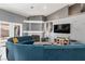Living room with curved sofa, fireplace, and large TV at 207 Charter Oak St, Henderson, NV 89074