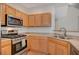 Modern kitchen with stainless steel appliances and wood cabinets at 2495 April Breeze Ln, Henderson, NV 89002