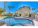 Large kidney shaped pool with brick coping and patio furniture, located in the backyard at 2572 Hidden Forest Cir, Henderson, NV 89074