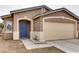 Tan exterior house with blue front door and attached garage at 5675 Halvern Ave, Las Vegas, NV 89110