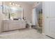 Well-lit bathroom featuring a dual sink vanity, tile flooring, and a glass-enclosed shower, all in a neutral color scheme at 6701 Dorita Ave # 201, Las Vegas, NV 89108